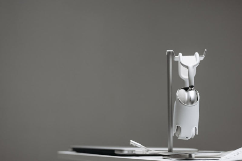 Silver device on a display stand against a gray background